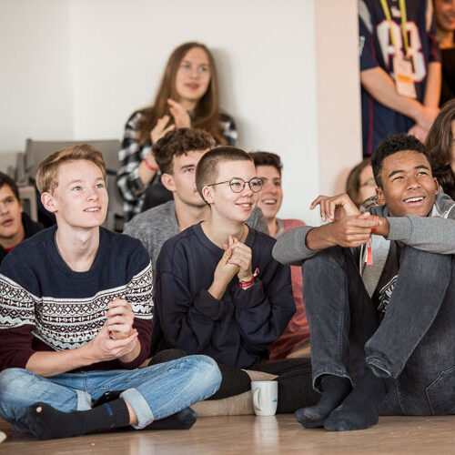 Jugend-Klima-Kongress 2023, Jugendliche sitzen während einer Session auf dem Boden und hören zu.