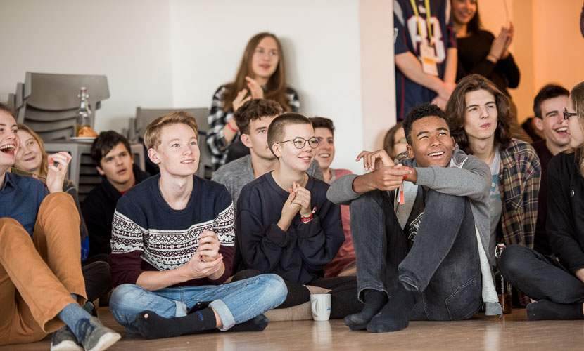Jugend-Klima-Kongress 2023, Jugendliche sitzen während einer Session auf dem Boden und hören zu.